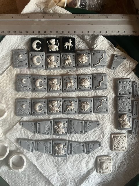 Ensemble des plaques du bracelet Artémis disposées avec une règle pour vérifier les dimensions