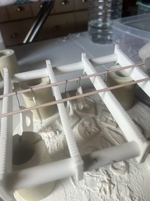 Pièces en porcelaine sur support de séchage à l'atelier Mila Bijoux