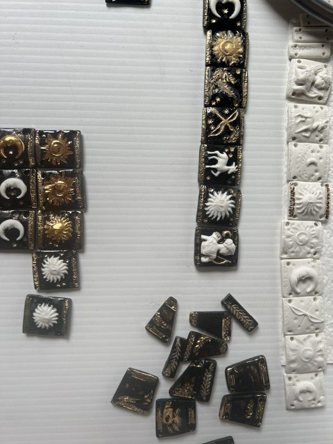 Comparaison des plaques du bracelet Artémis : porcelaine blanche, émaillée noire, puis rehaussée d'or
